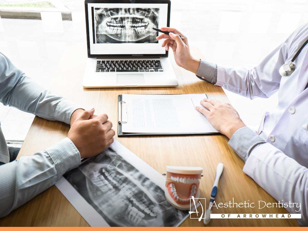 A qualified dentist explaining his patient why translucent teeth are a sign for enamel loss in Glendale, AZ